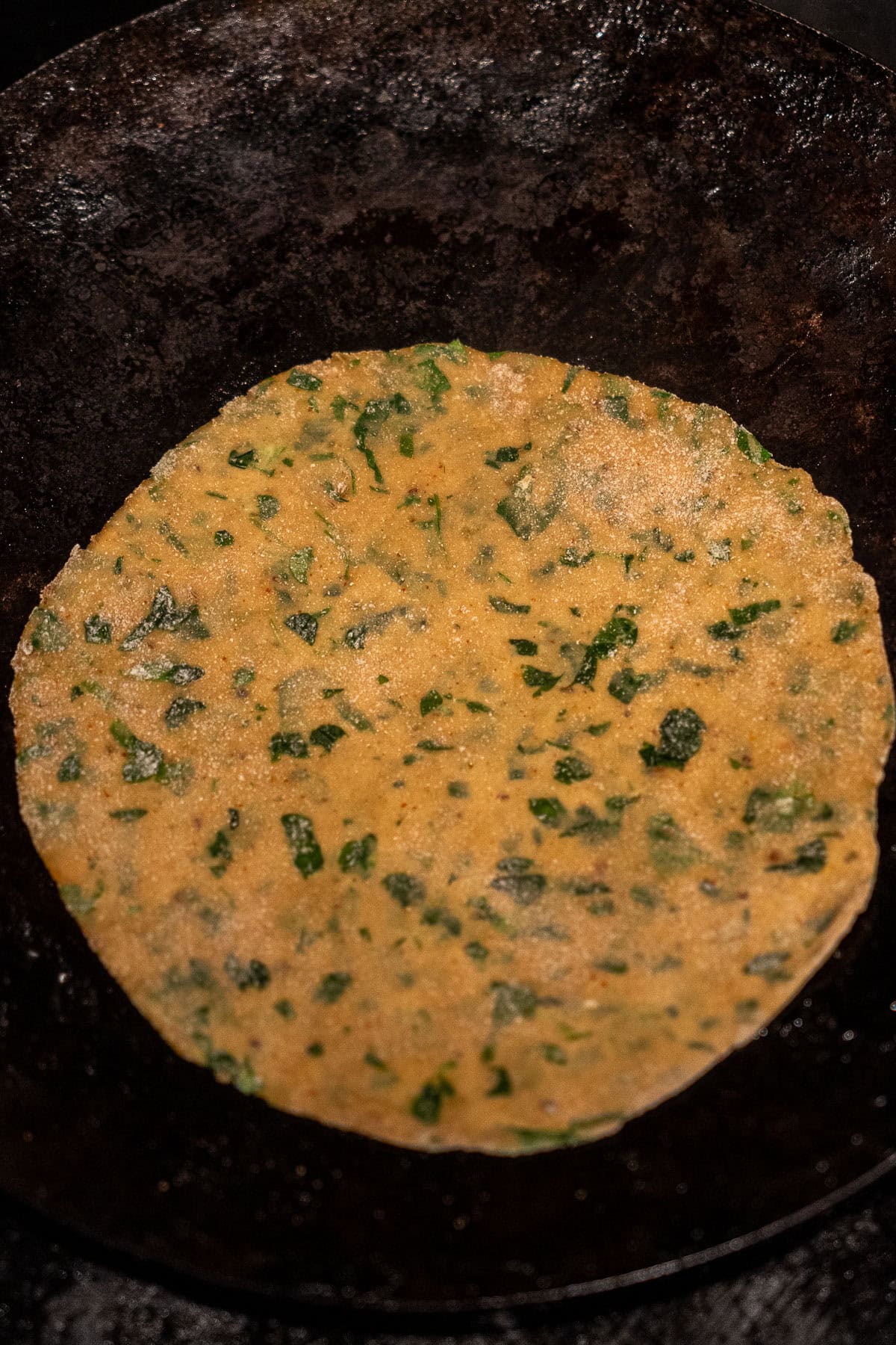 Raw methi paratha on a tawa.