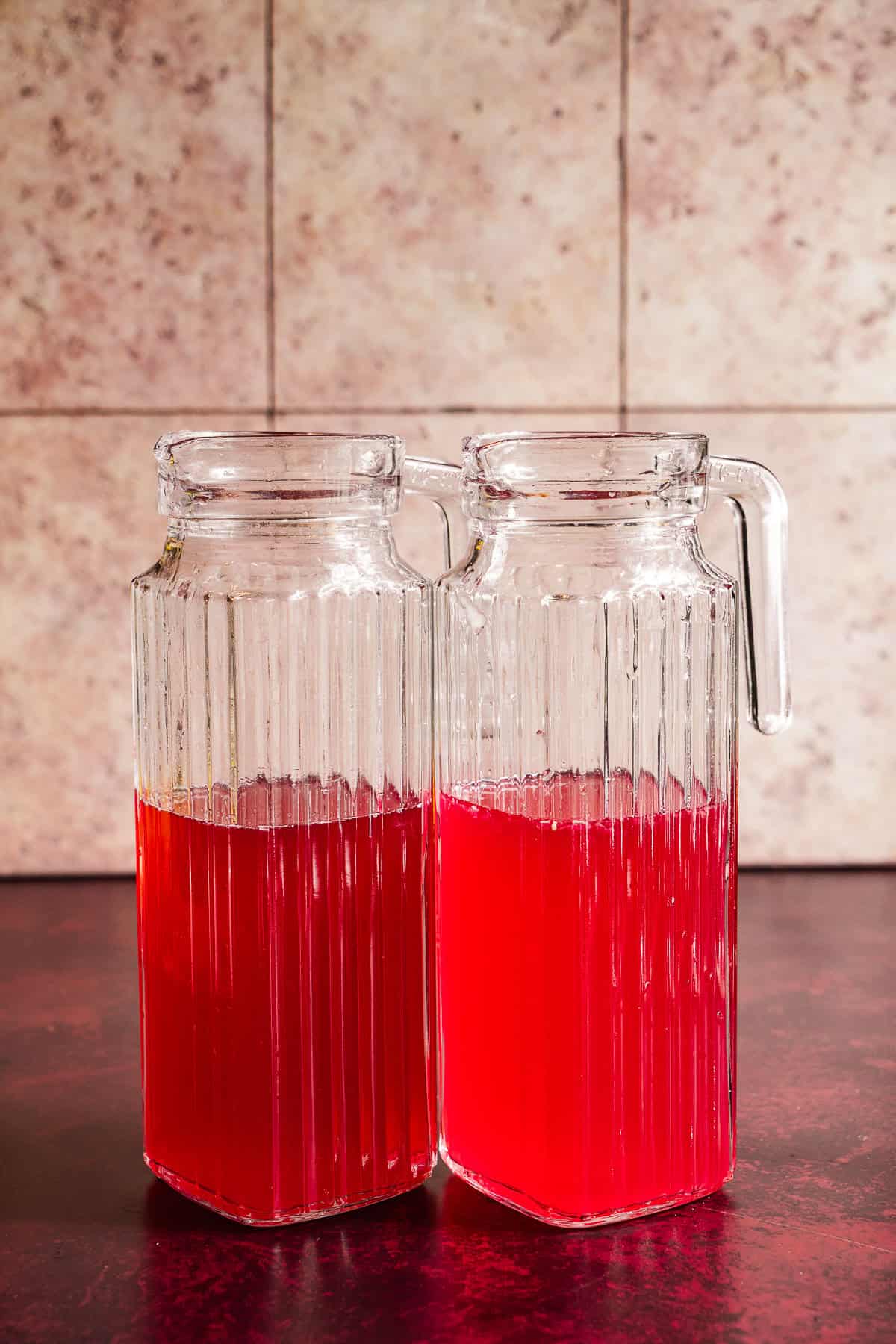Hibiscus lemonade concentrate in pitchers.