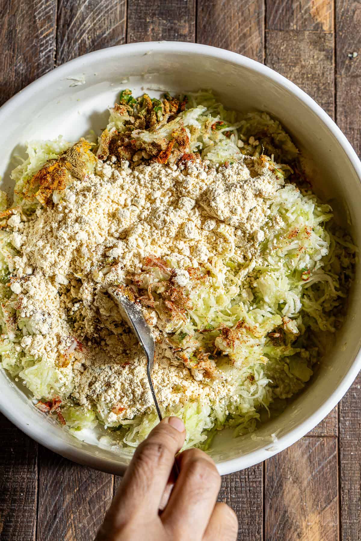 Mixing together a bowl of lauki kofta batter with besan.