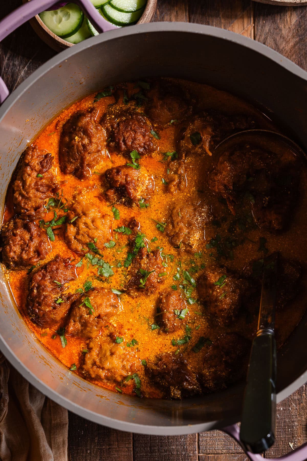 A deep pot with Lauki Kofta Curry with a serving spoon.