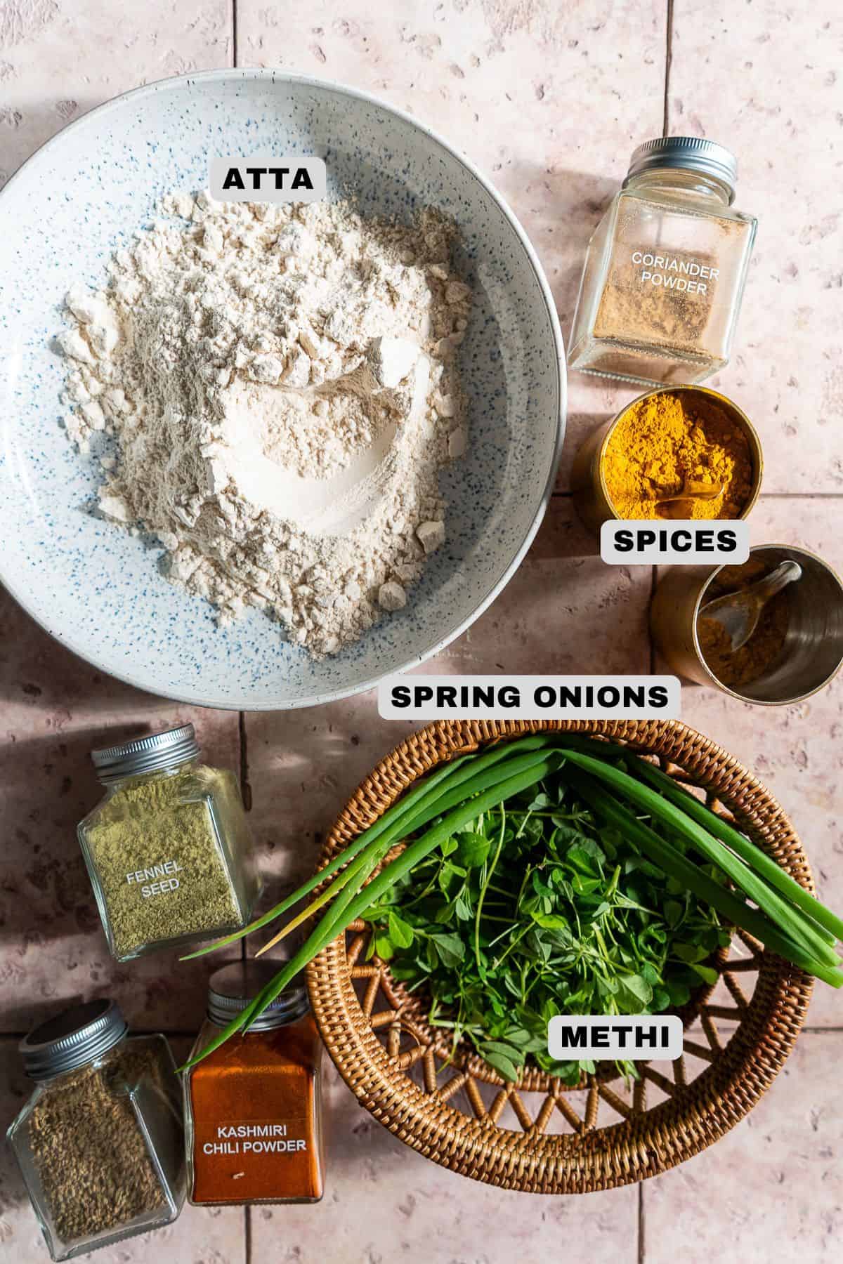 Atta, spices, spring onions, and fresh fenugreek ingredients with labels.