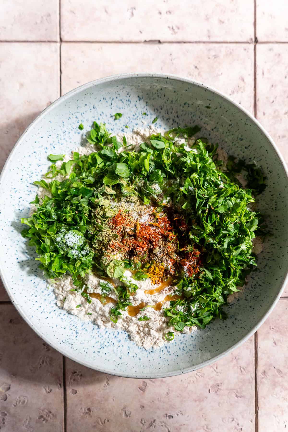 Ingredients for methi paratha combined in a bowl.