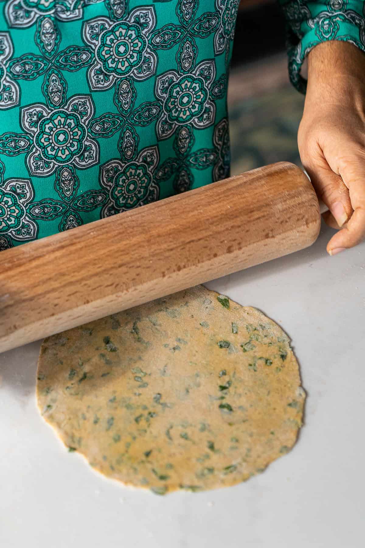 Rolling out a paratha with a rolling pin.