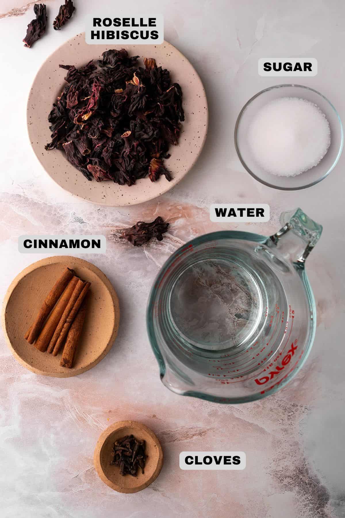 Roselle Hibiscus, sugar, water, cinnamon, cloves ingredients with labels.