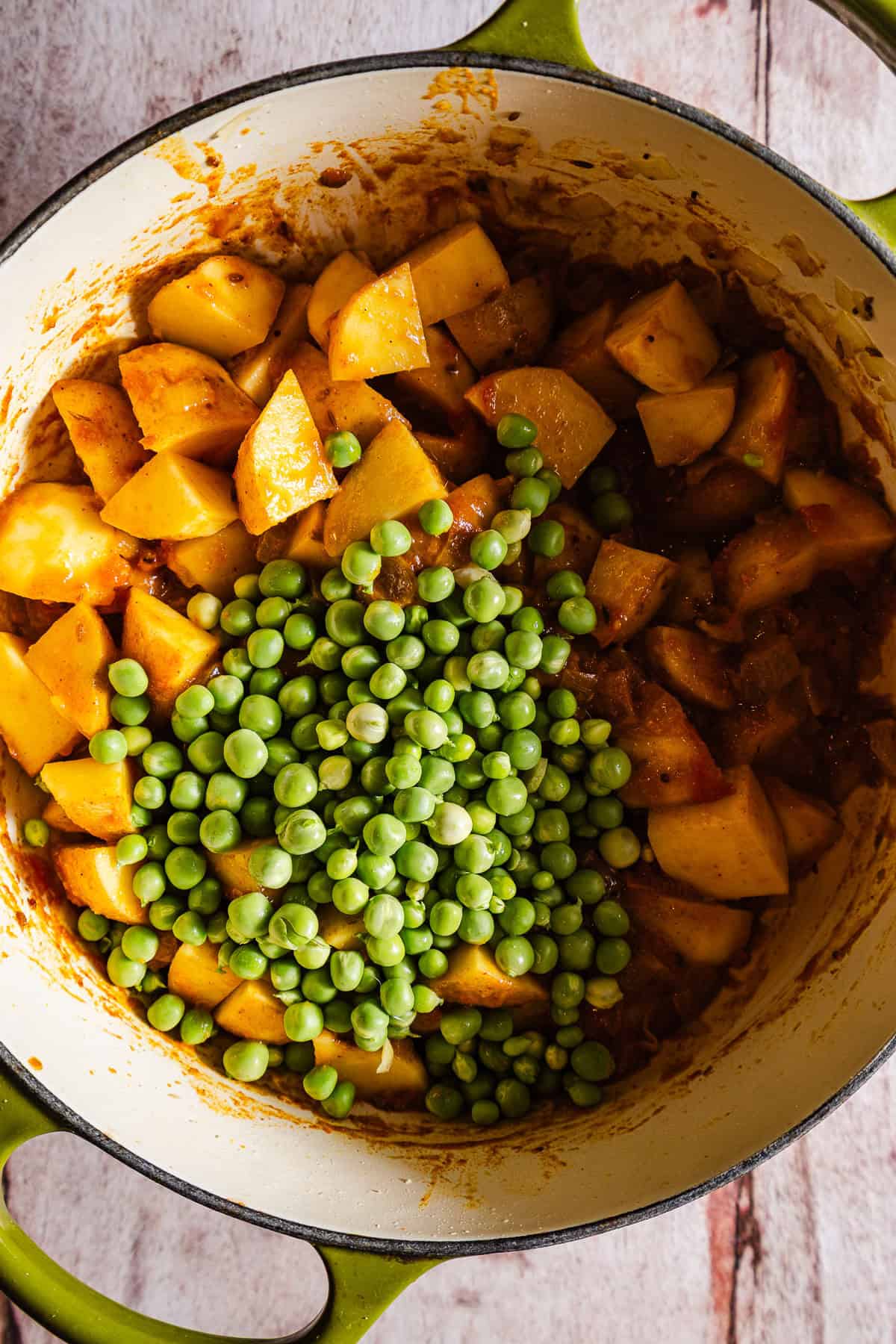 Raw peas over potatoes in a tomato gravy.