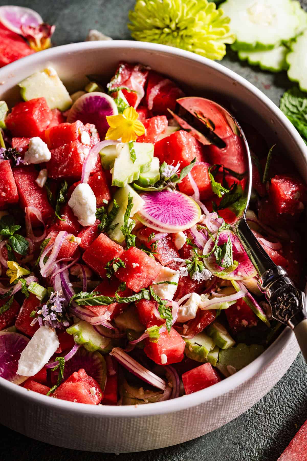 Watermelon Feta Salad in a bowl with fresh edibles flowers.