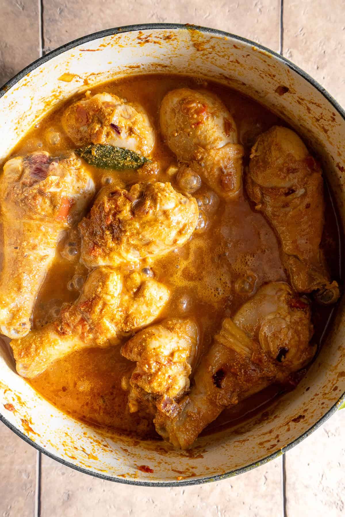 Chicken drumsticks parcooked and covered with soupy dahi onion tomato masala.