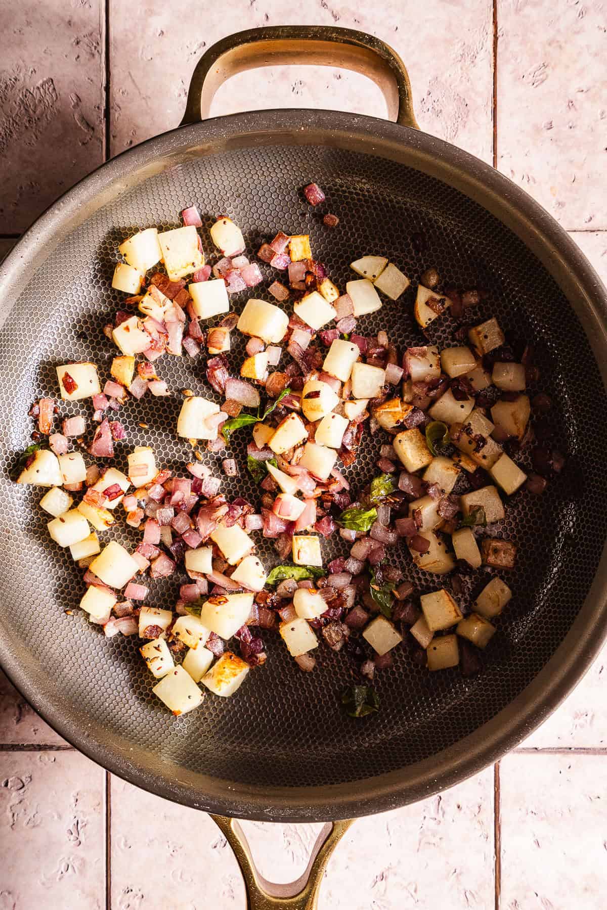 Stir-fried vegetables with peas and potatoes in a skillet.