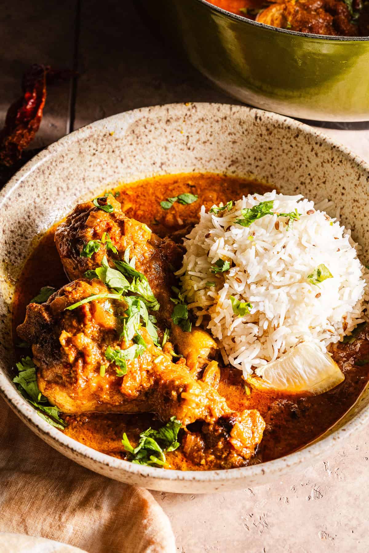 Chicken curry with a mound of rice in a bowl.