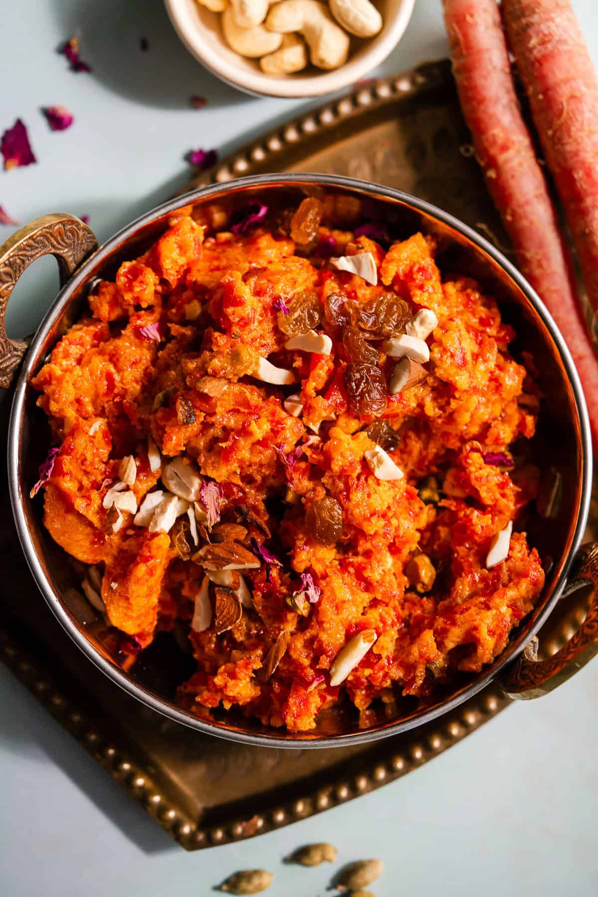 Gajar ka halwa in an Indian kadhai serving bowl served with nuts.